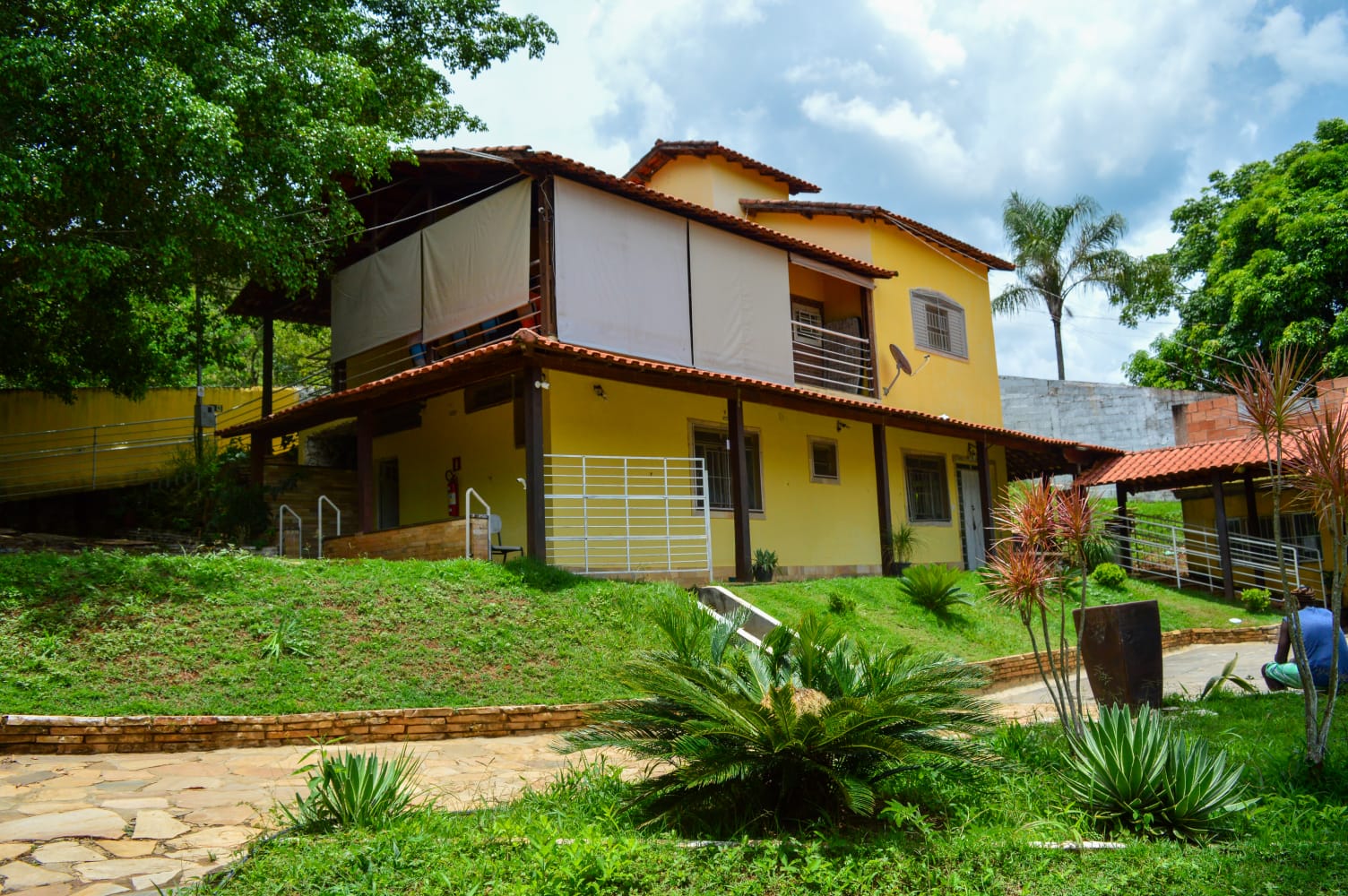 Casa sede da comunidade terapêutica vista do jardim arborizado